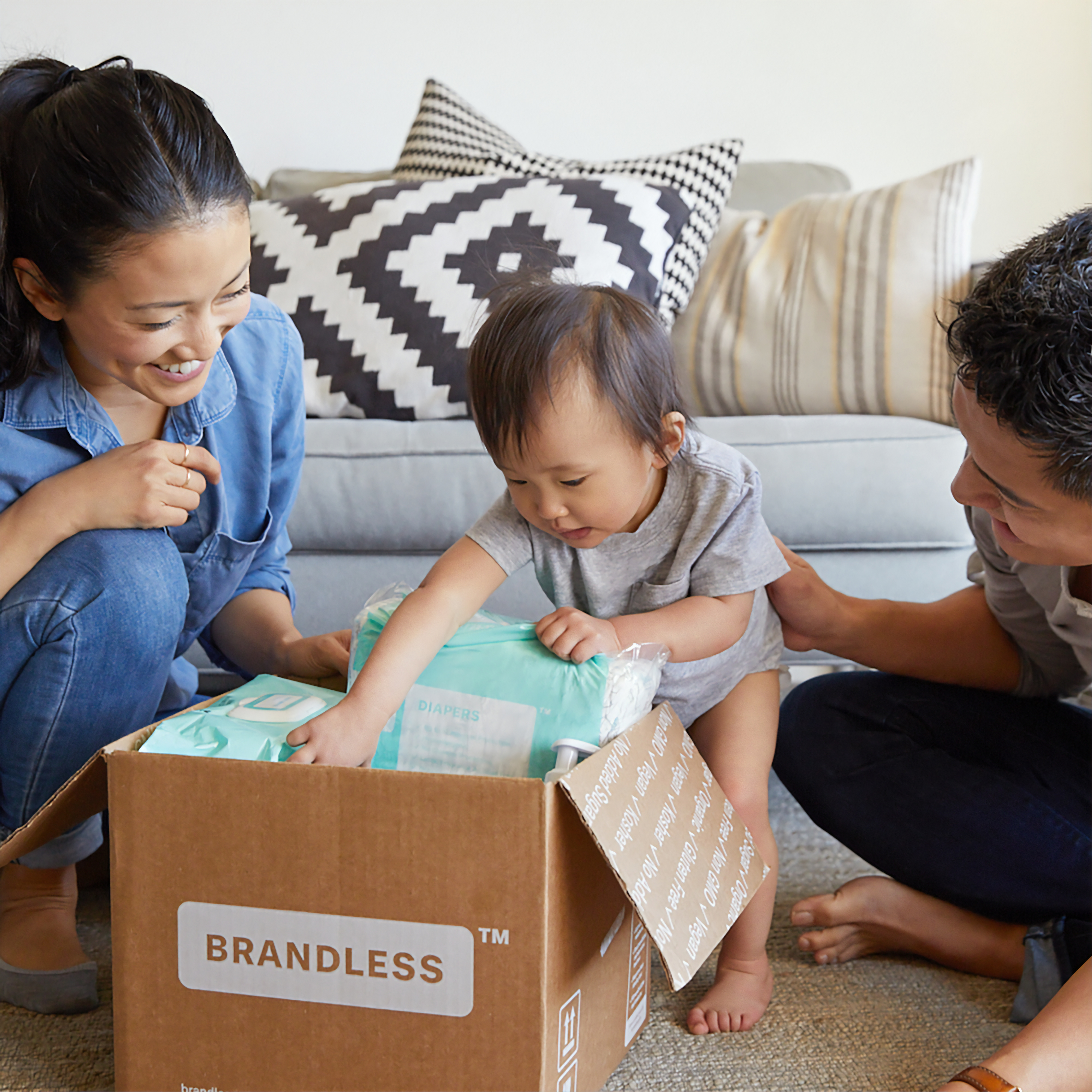Moving up: Young family with baby opening a box